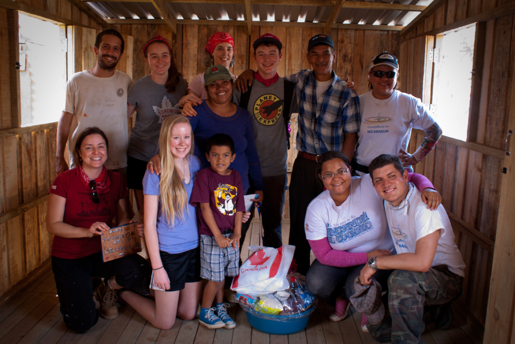 One of our house-building teams and the family who's house they helped build.